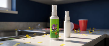 Two white novelty stink spray bottles with green labels on a kitchen counter